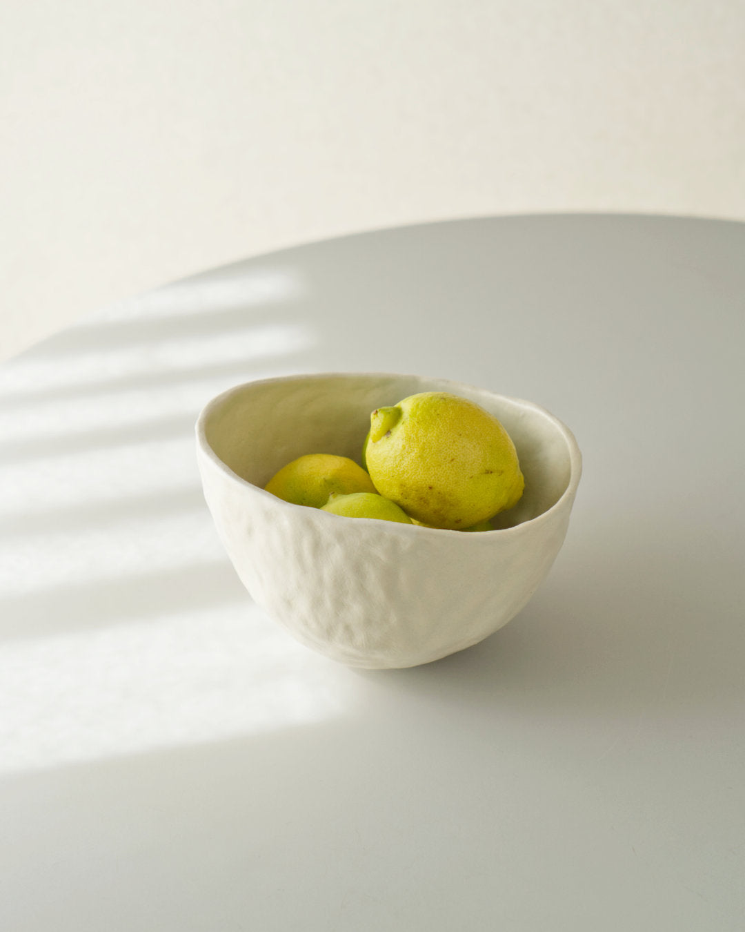 A white ceramic bowl with lemon made by Misa Asanuma